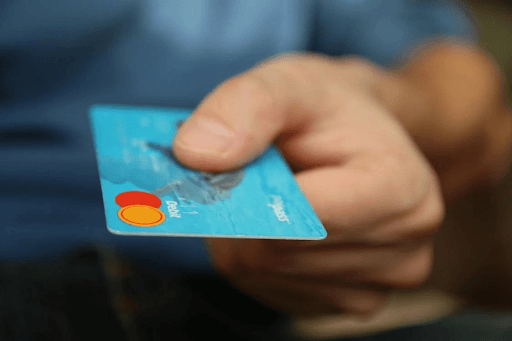 A hand holding a credit card, emphasizing the importance of understanding credit card debt and its statute of limitations.