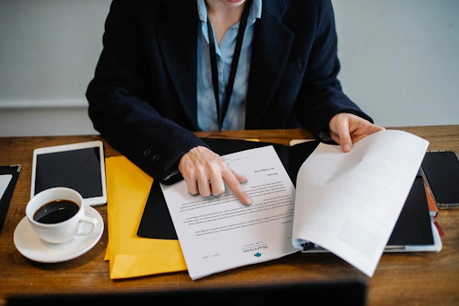 A person reviewing financial documents at a desk, highlighting the importance of accurate documentation.