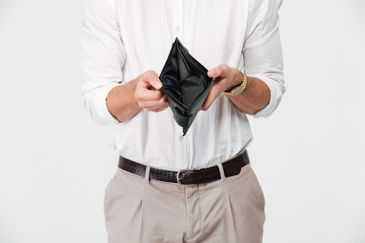 Man holding an open, empty wallet.