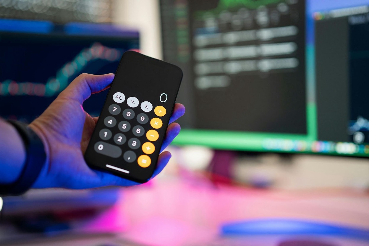 A hand holding a smartphone calculator