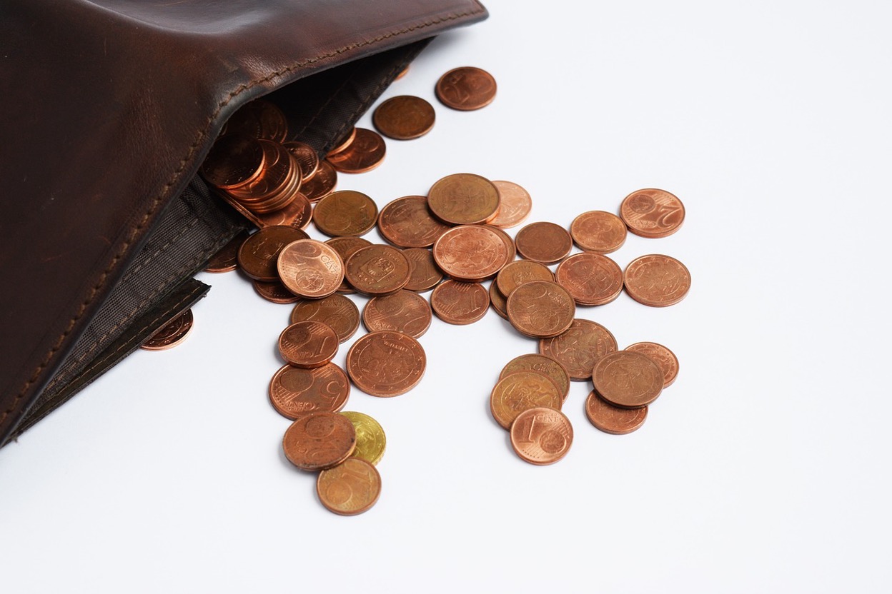 A wallet spilling coins