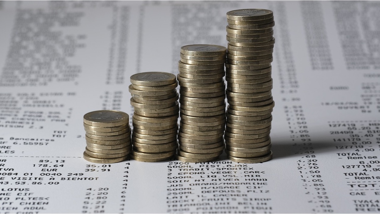 Stacked coins representing growing financial pressure.